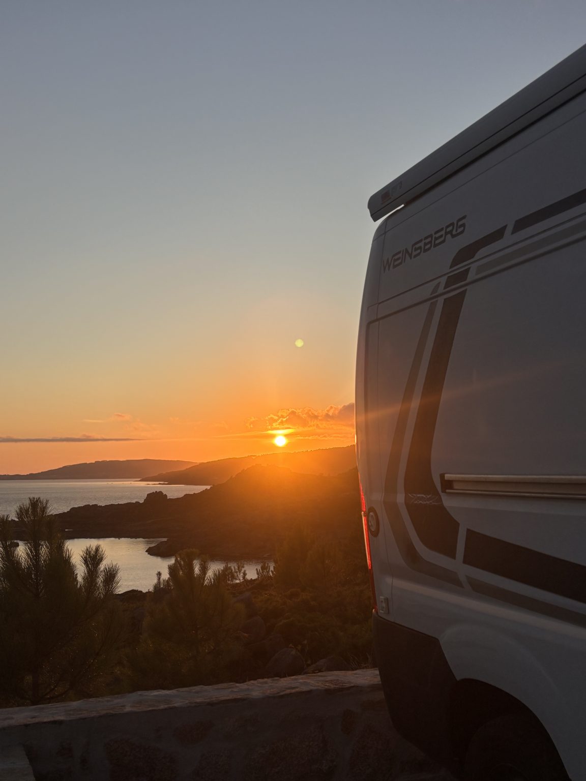 Camper frente al mar al atardecer durante una experiencia NUMA