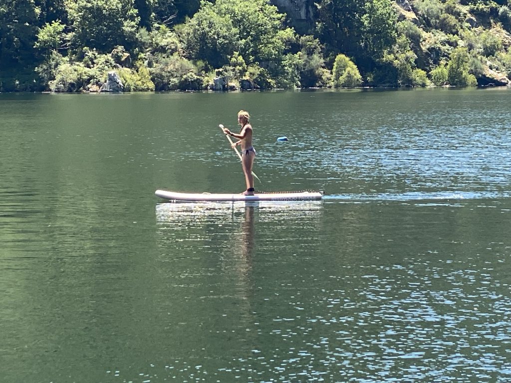 Mujer practicando paddle surf en un entorno natural durante una experiencia NUMA